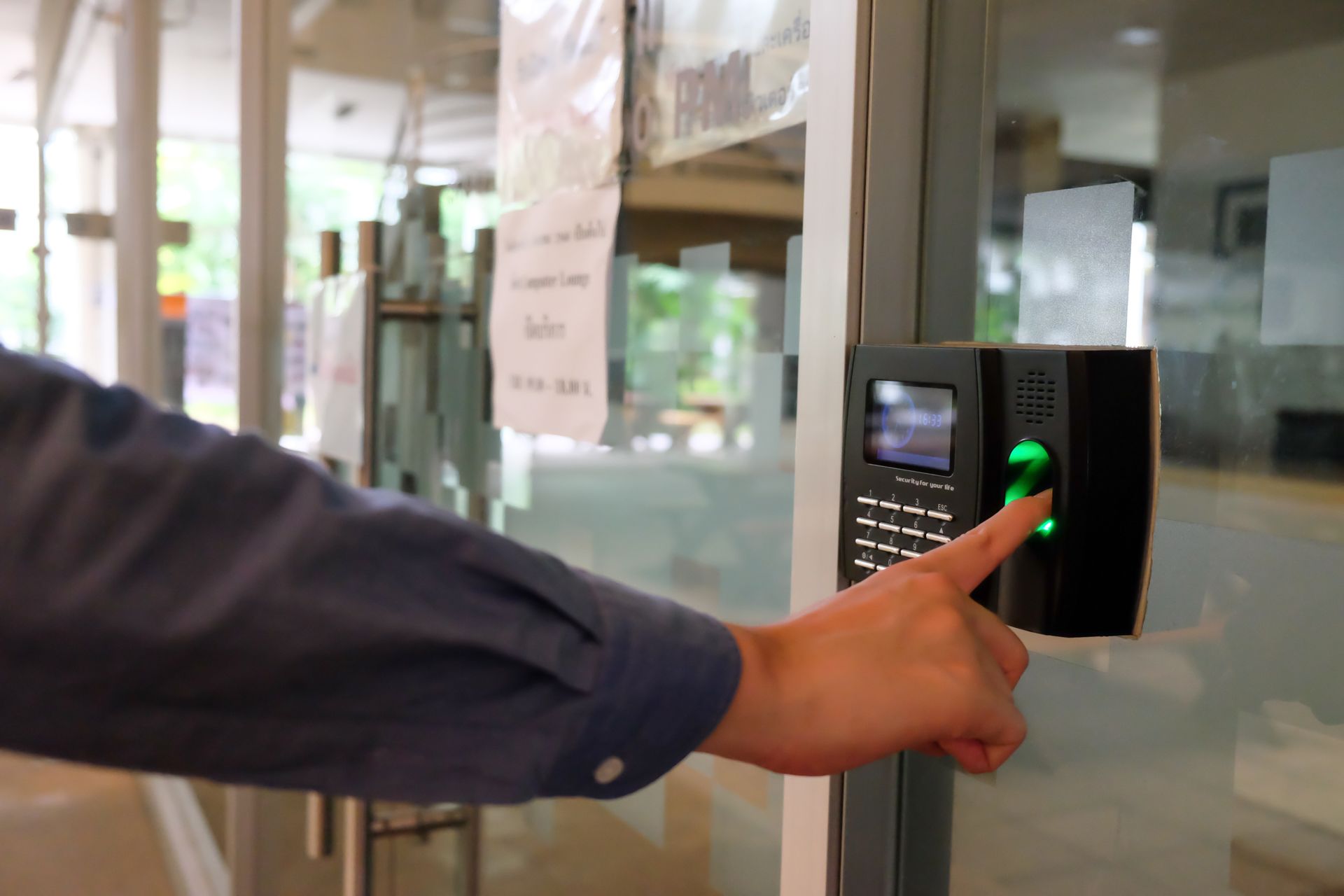 A person is using a fingerprint scanner to open a door.