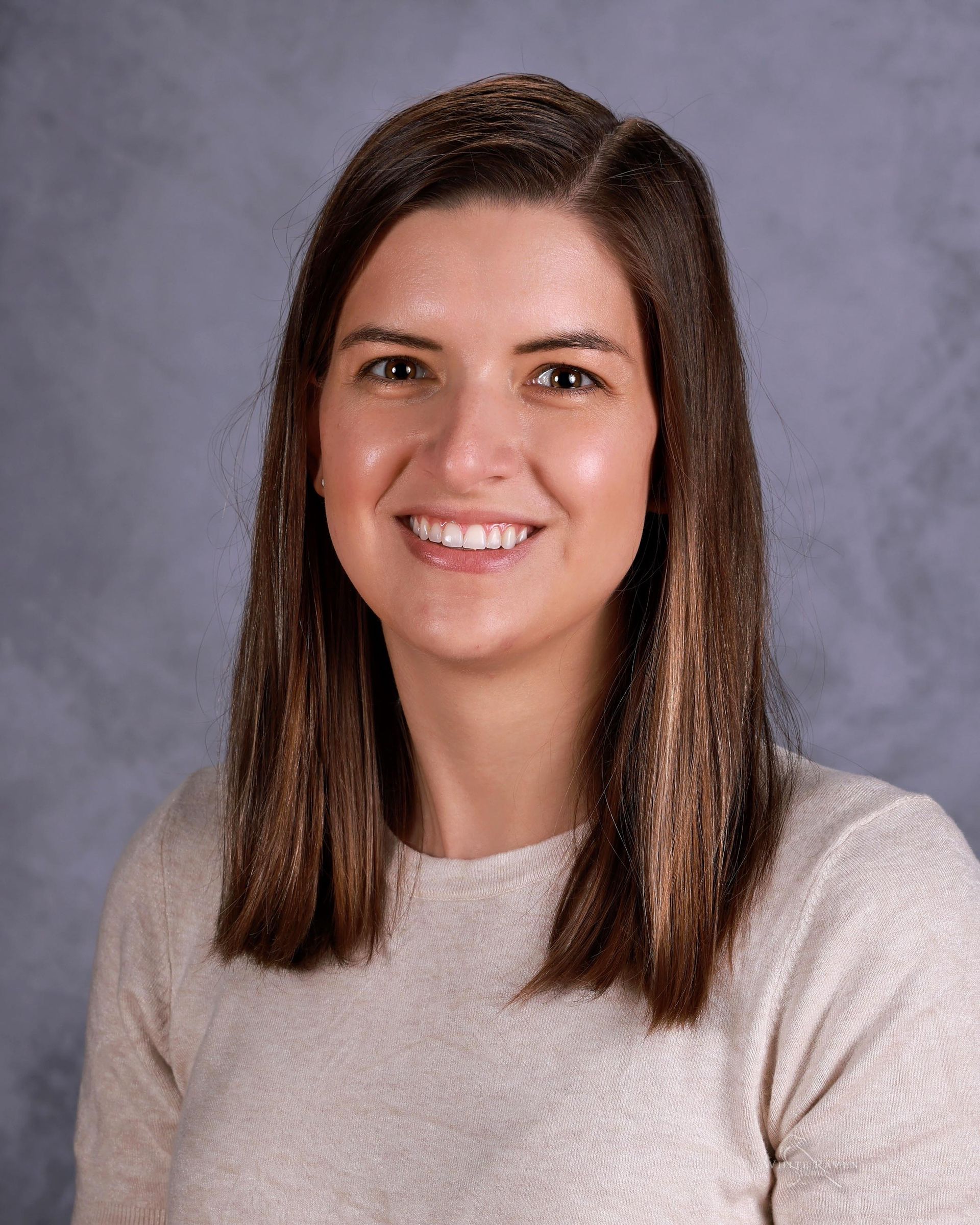 A woman with blonde hair and a black shirt is smiling for the camera.