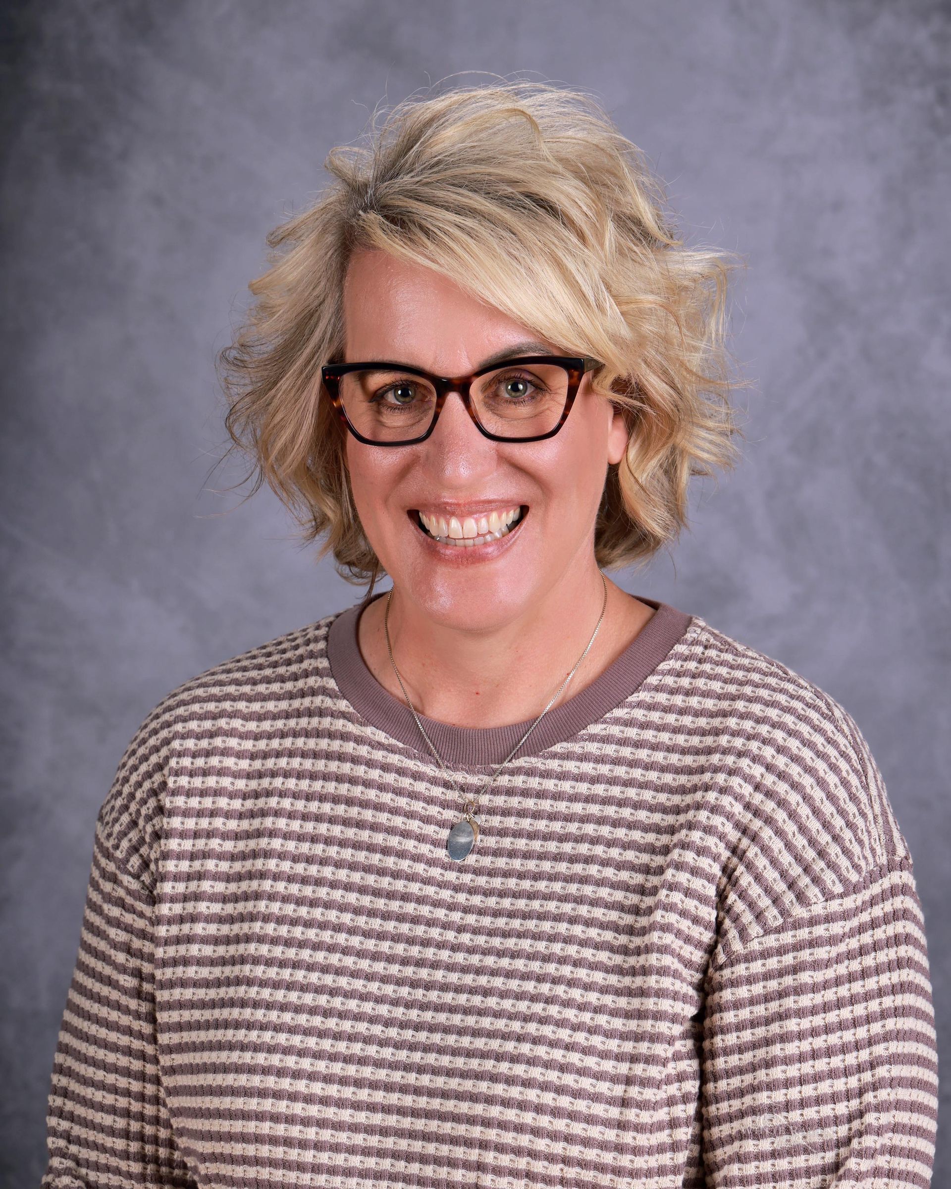 A young woman with long brown hair is smiling for the camera.