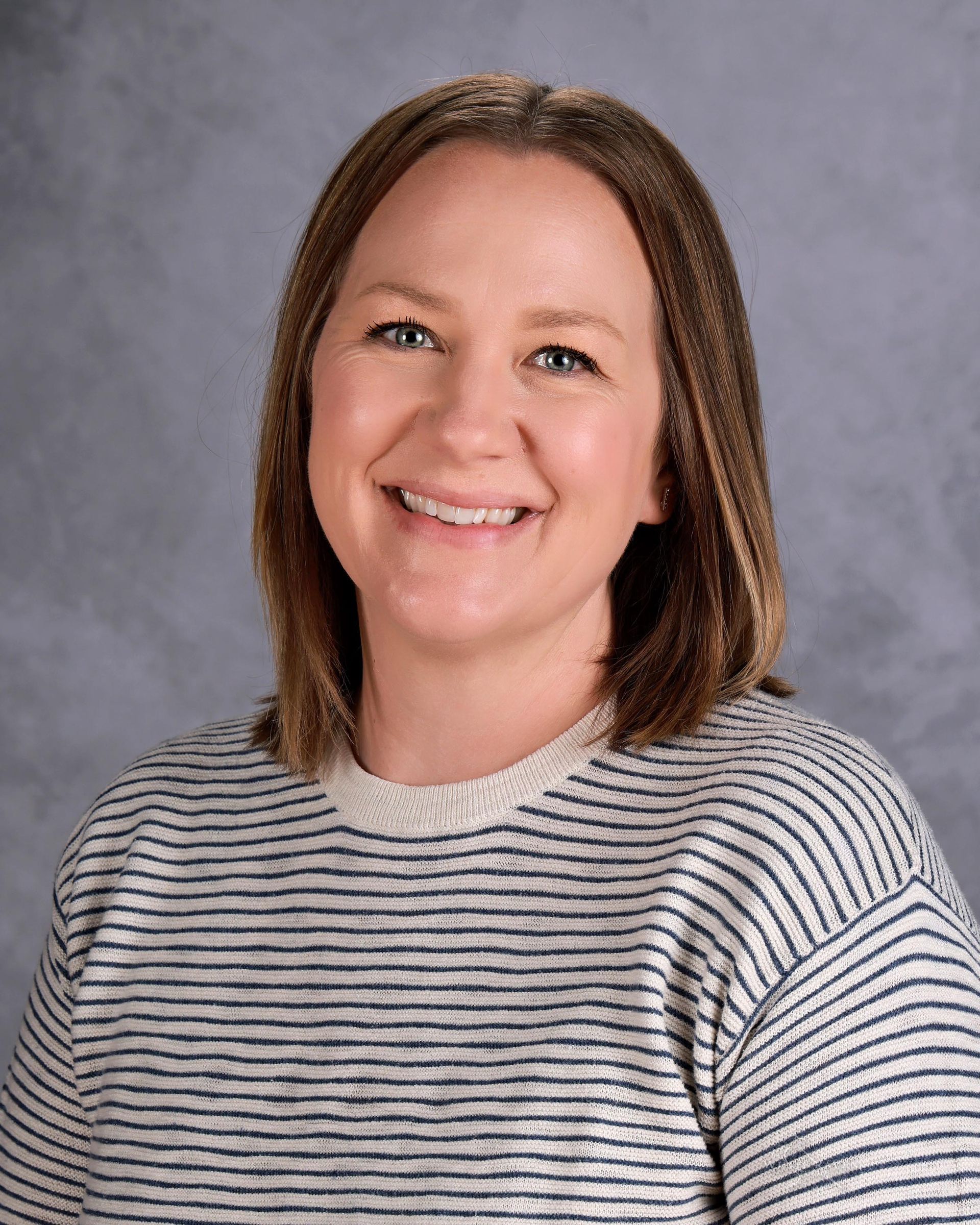 A woman in a black shirt is smiling for the camera.