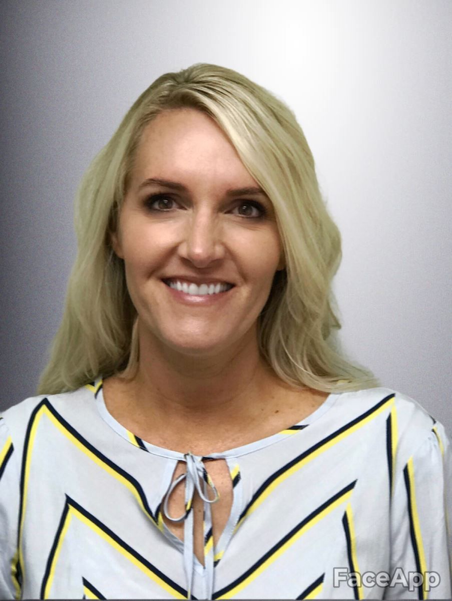 A woman in a striped shirt is smiling for the camera