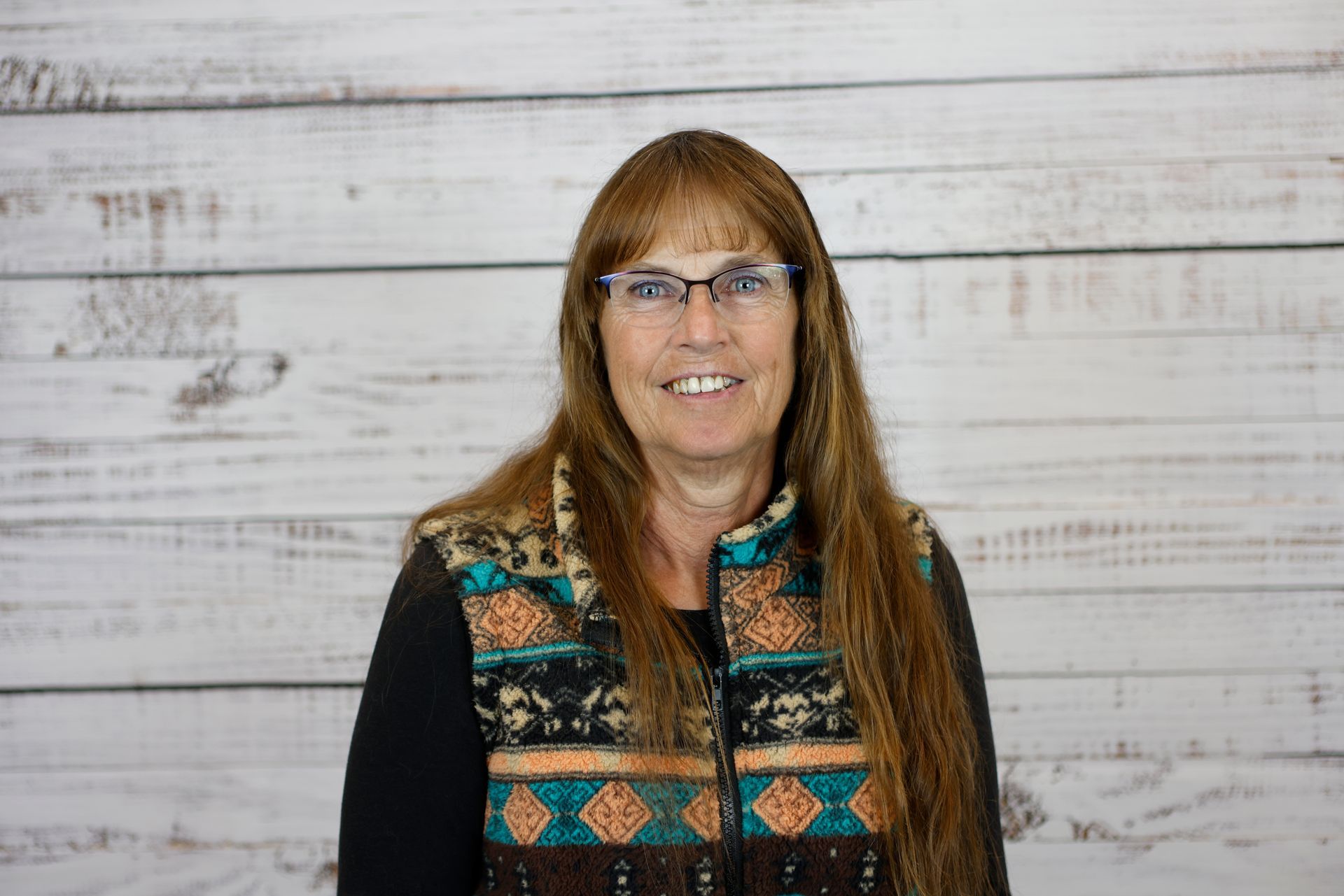 A young woman with long brown hair is smiling for a picture.