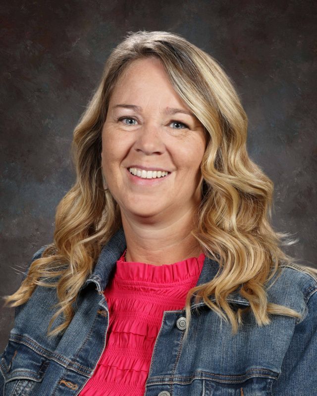 A woman with long blonde hair is smiling for the camera.