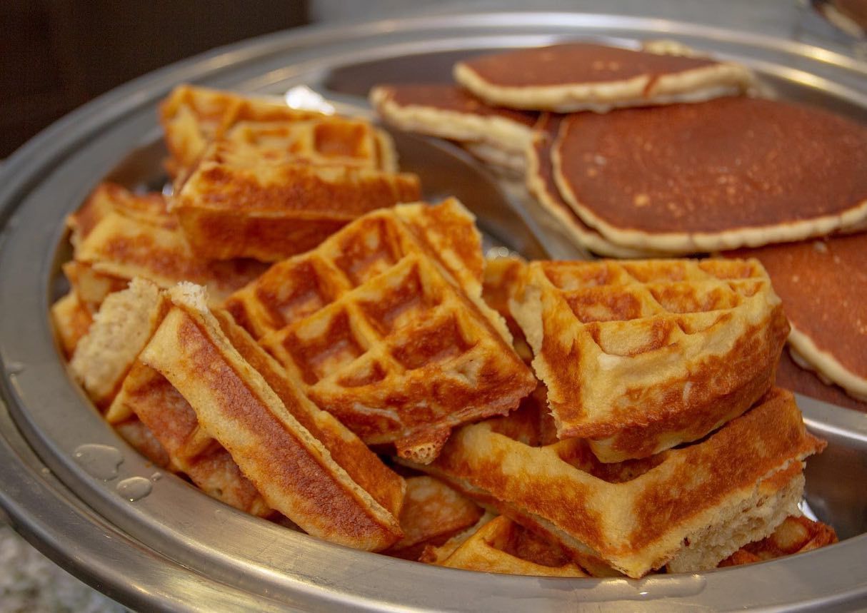 Gofres y tortitas en una bandeja metálica, dorados.