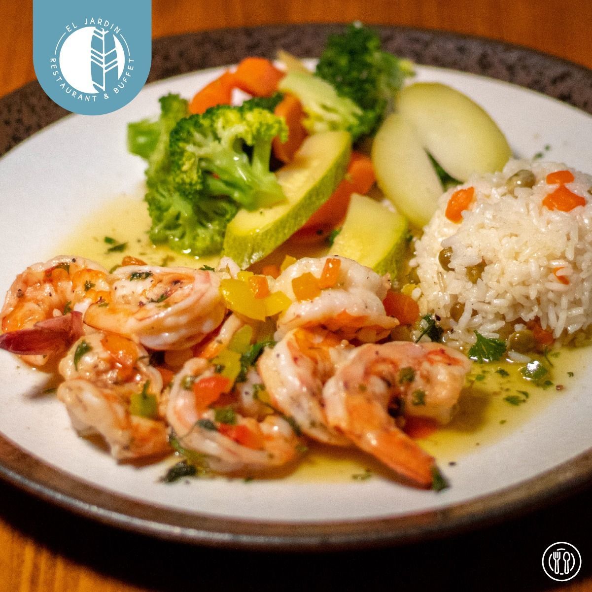 Gambas al ajillo con arroz y verduras en un plato.