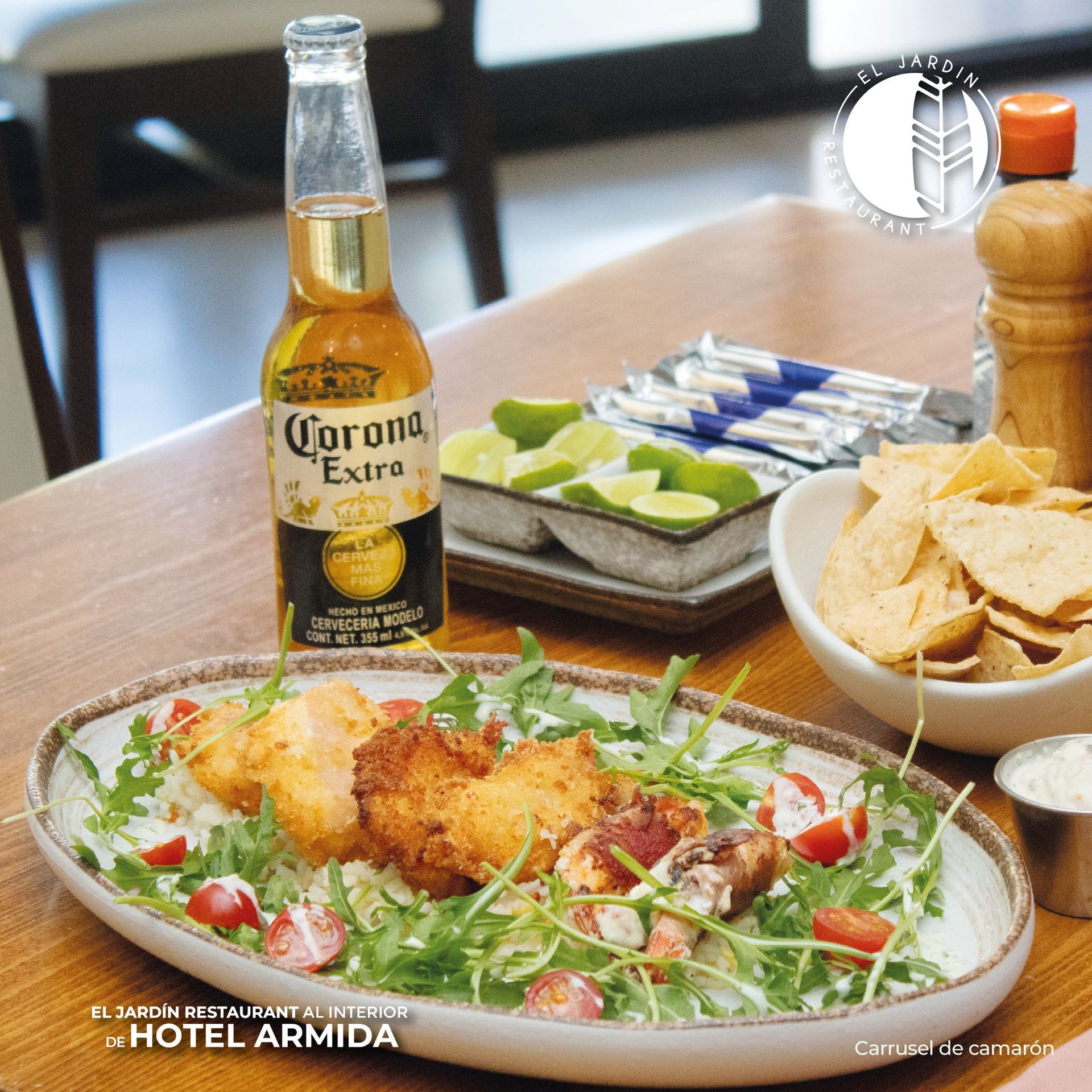 Cerveza Corona, comida frita, totopos y limas sobre una mesa en el restaurante El Jardín, Hotel Armida.