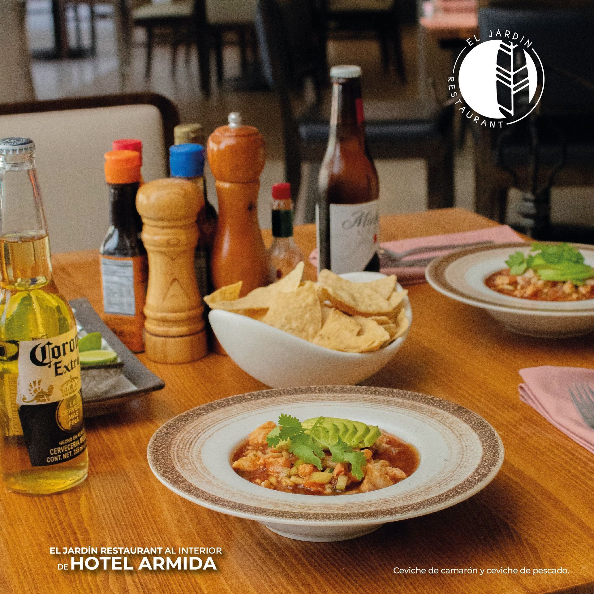 Mesa puesta con ceviche, totopos, condimentos, cerveza y el logotipo del restaurante.