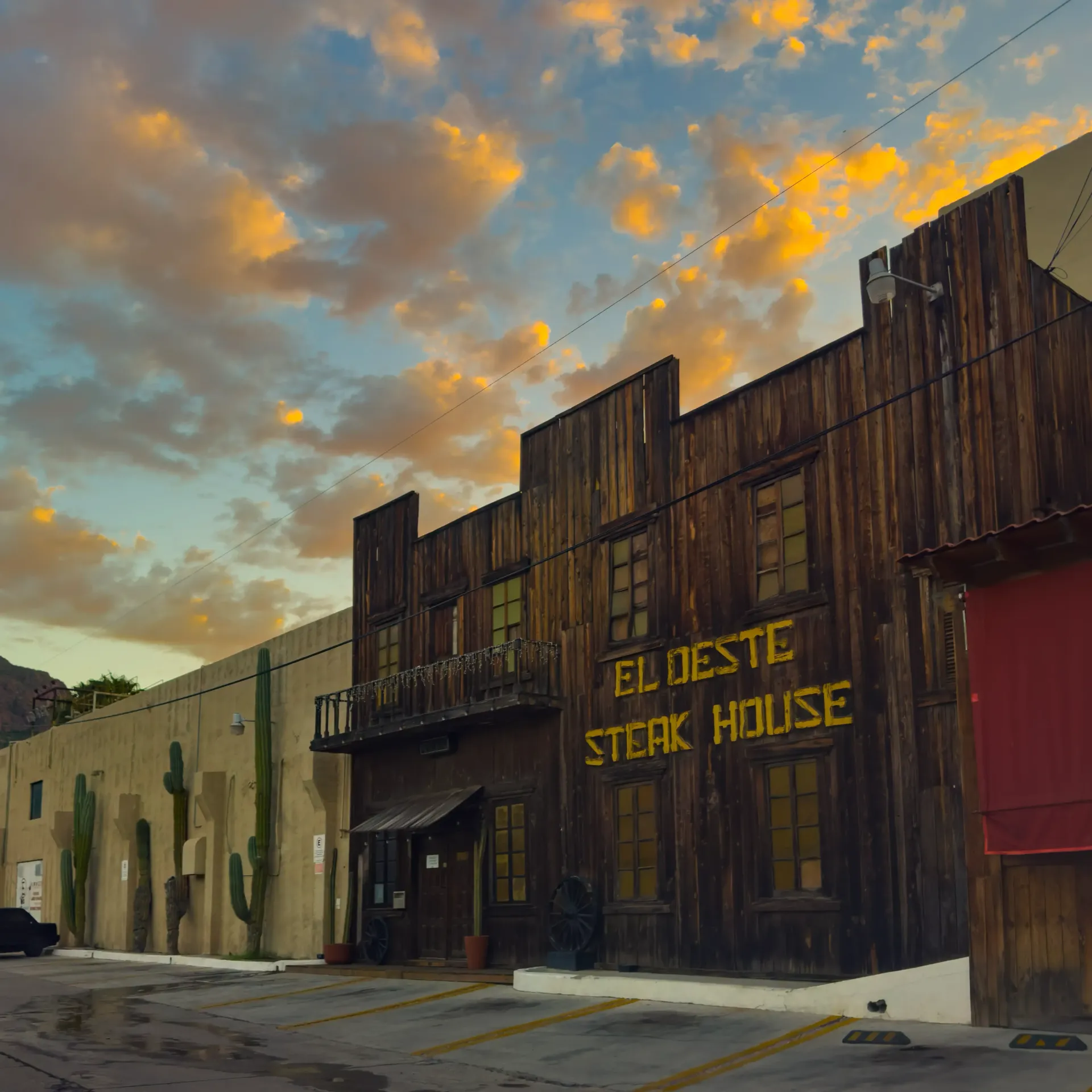 Edificio del restaurante El Oeste Steak House, de estilo occidental, con fachada de madera marrón.