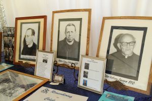 Framed black-and-white portraits and informational placards displayed on a table in a museum exhibit