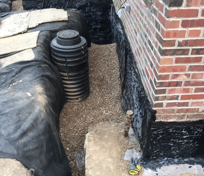 A brick wall with a black tarp covering it