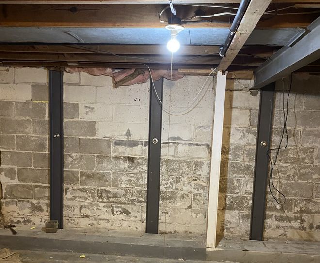 A basement with brick walls and a light hanging from the ceiling