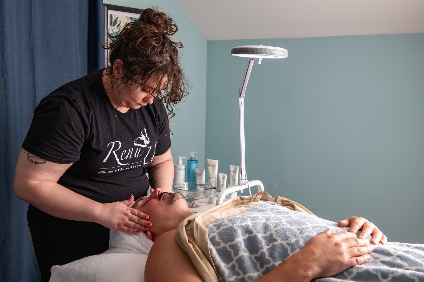 Esthetician giving a facial massage in a spa setting.