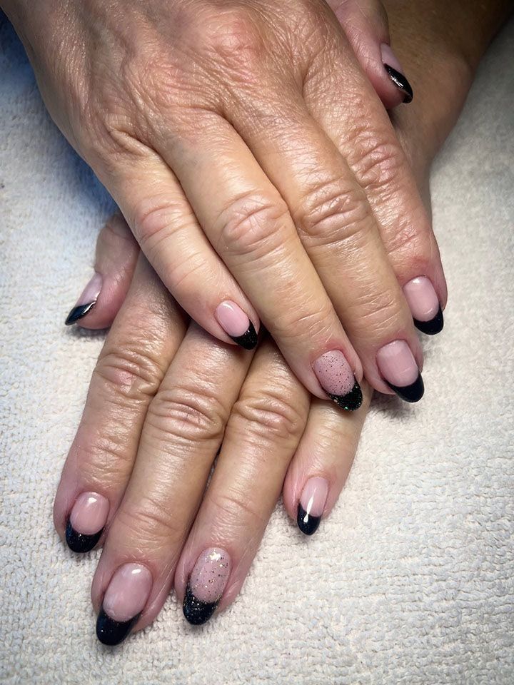 Hands with black French tip manicured nails.