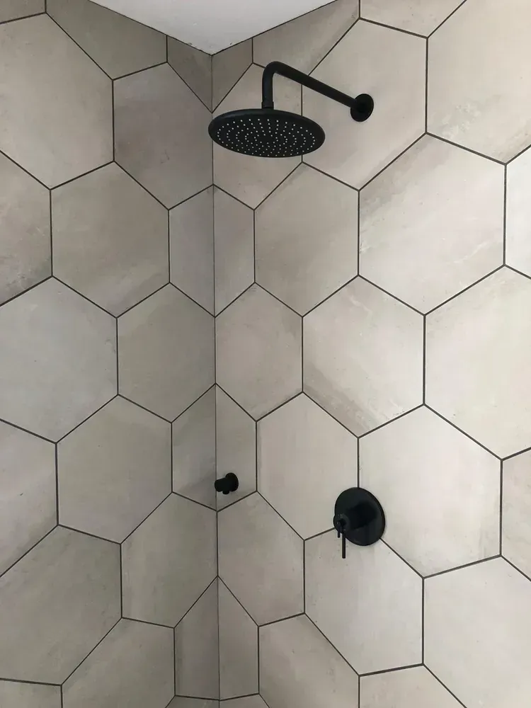 There is a shower head in the corner of the shower.