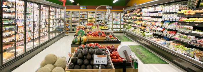 A grocery store with refrigerated cases on the sides, fresh produce in the center.