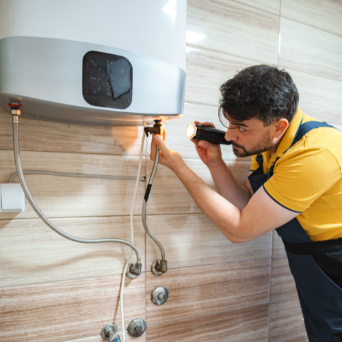 Hand adjusting a smart thermostat showing 22 degrees on a white wall in a living room.