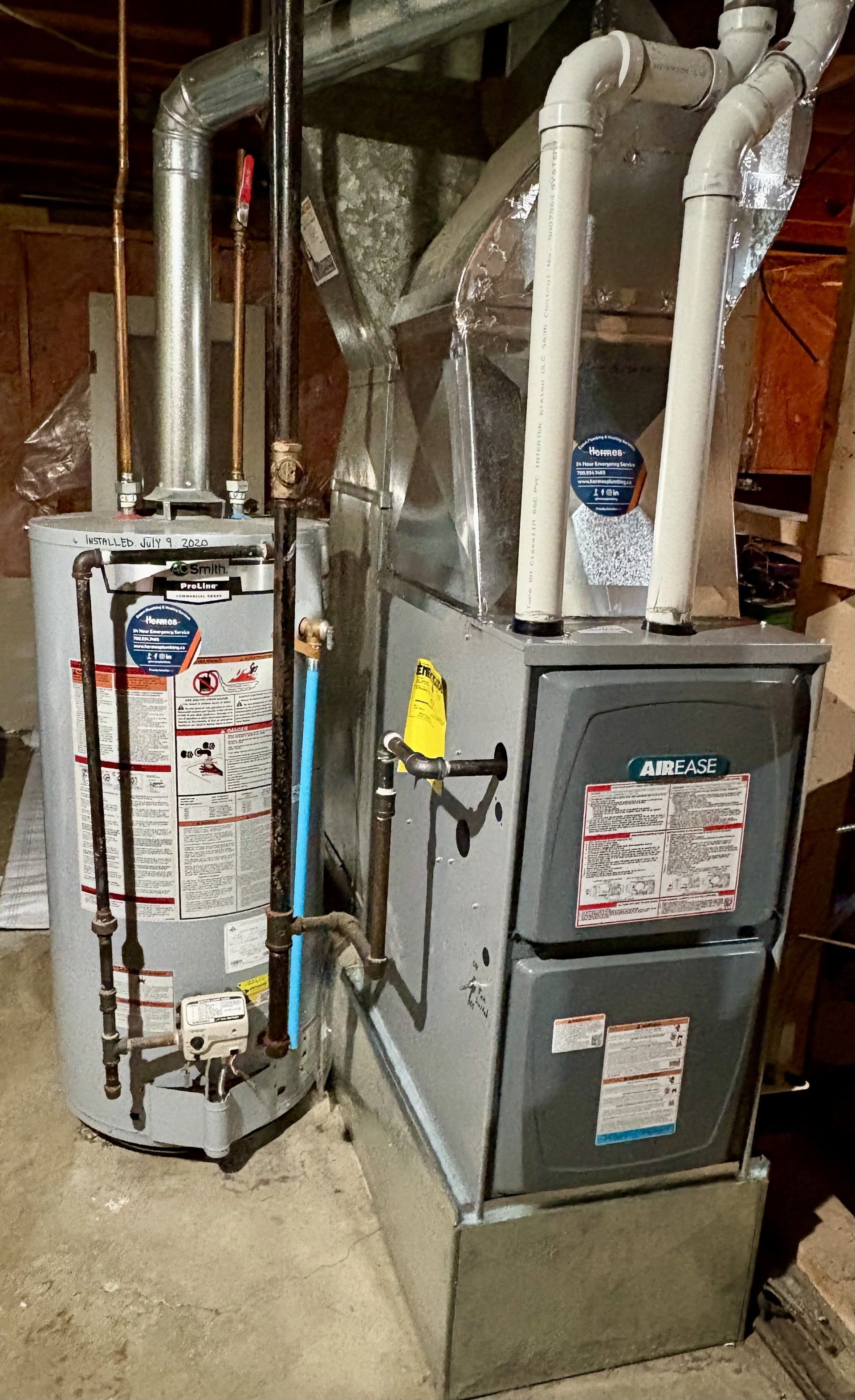 A silver water heater is hanging on a wooden wall.