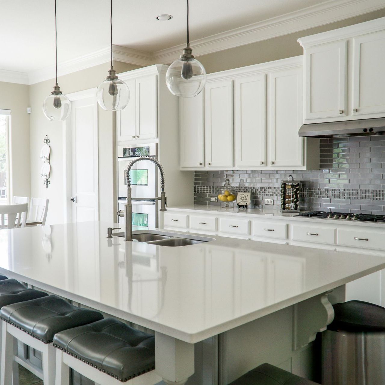 A kitchen with white cabinets and a large island