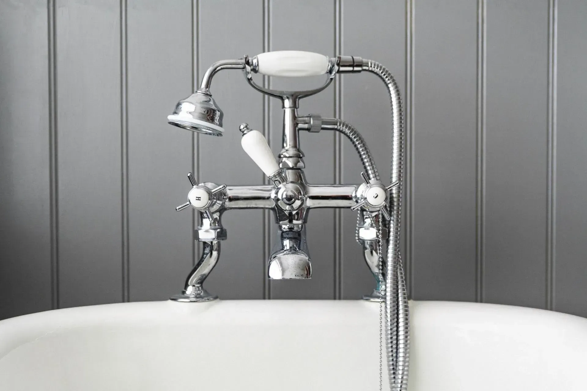 A bathtub with a chrome faucet and a shower head.