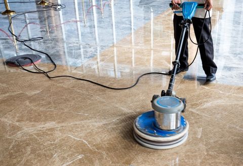 man polishes floor indoors