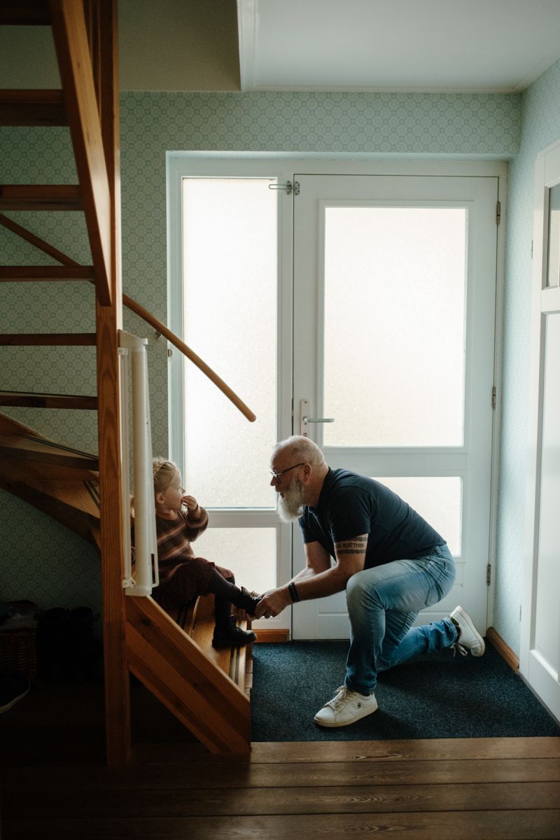 Opa strikt de veters van de schoenen van de kleindochter