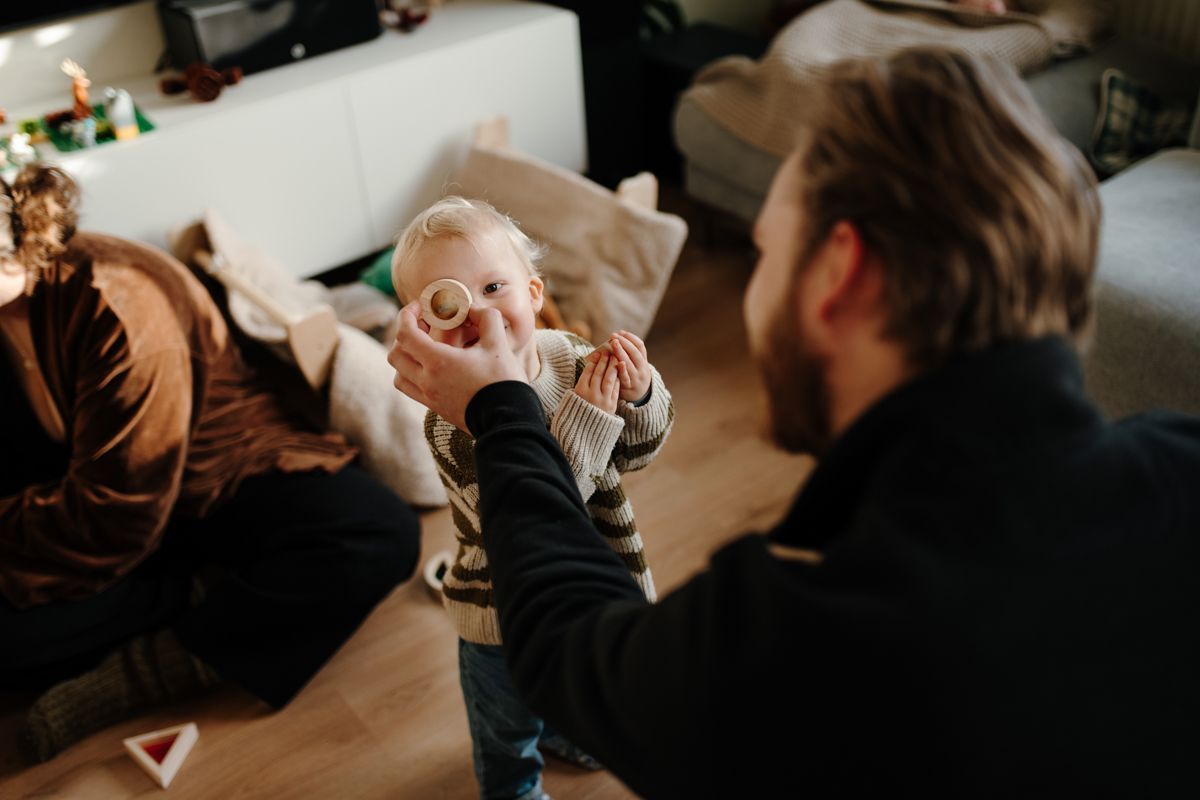 Vader en zoon spelen tijdens een fotoshoot in de woonkamer