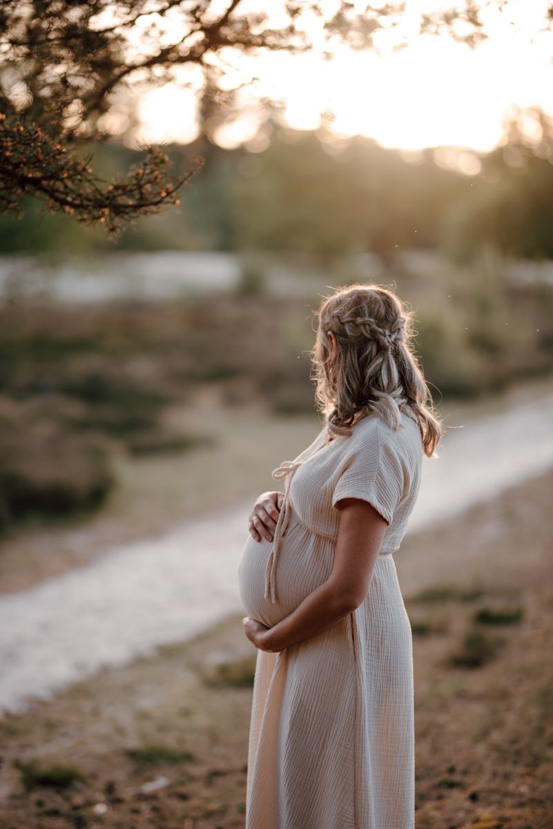 Zwangere vrouw tijdens een fotoshoot in de avondzon