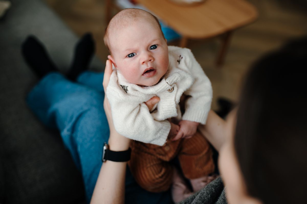 Baby op schoot bij moeder tijdens de newbornshoot in Sneek, Friesland