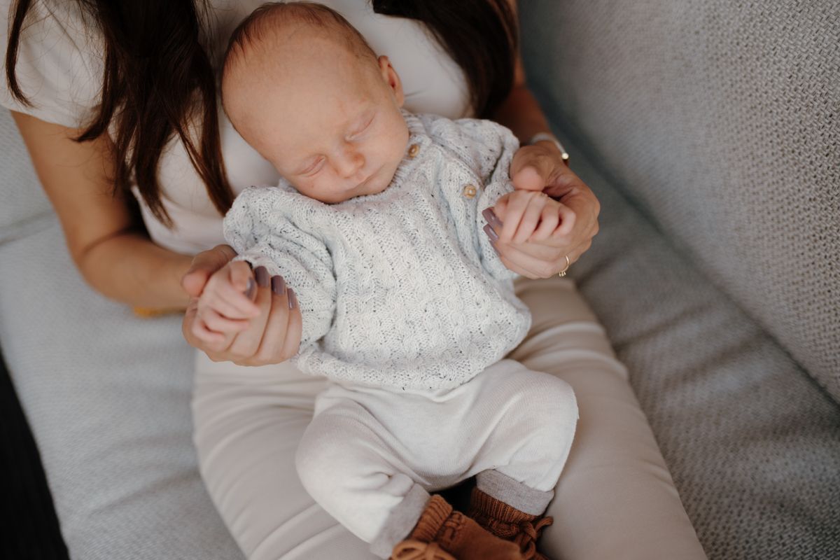 Newbornbaby samen met moeder op de bank