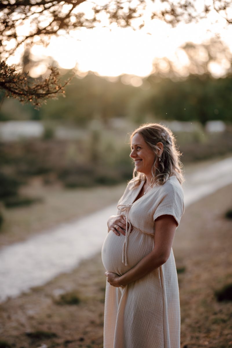 Mooie zwangere vrouw op de foto tijdens een zonsondergang