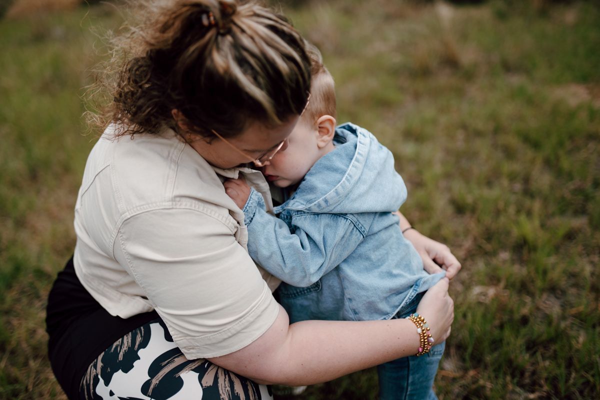 Kindje knuffelt met moeder tijdens een fotoshoot