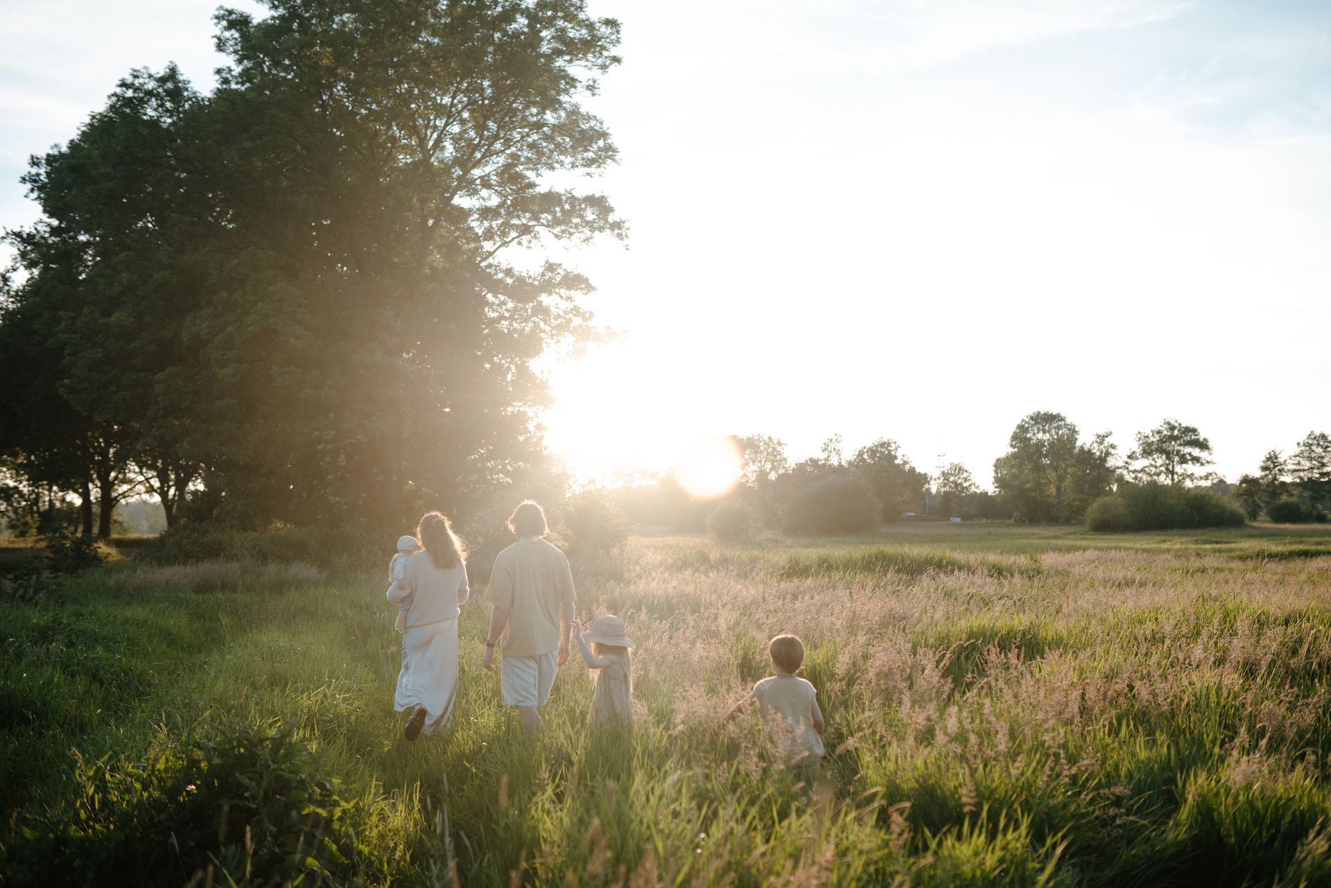 Gezin in het hoge gras tijdens een gezinsfotoshoot in de natuur