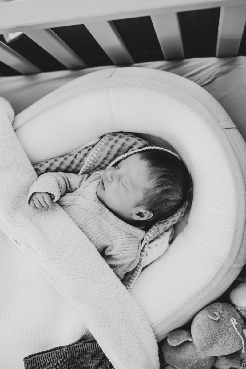 Baby ligt lekker te slapen in de box tijdens een fotoshoot