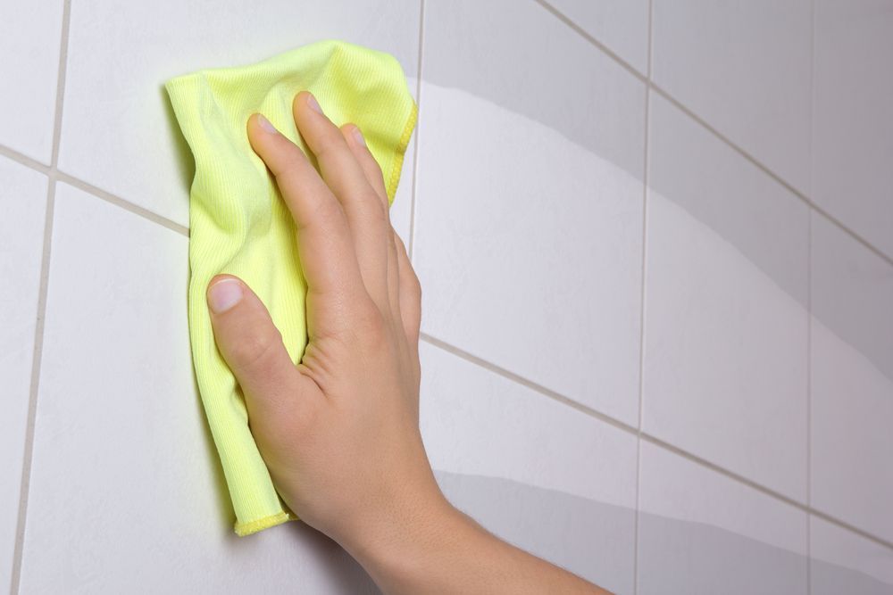 A Person Wearing Cleaning A Tile Floor With A Yellow Cloth — Citrus Clean Central Coast In Lake Haven, NSW