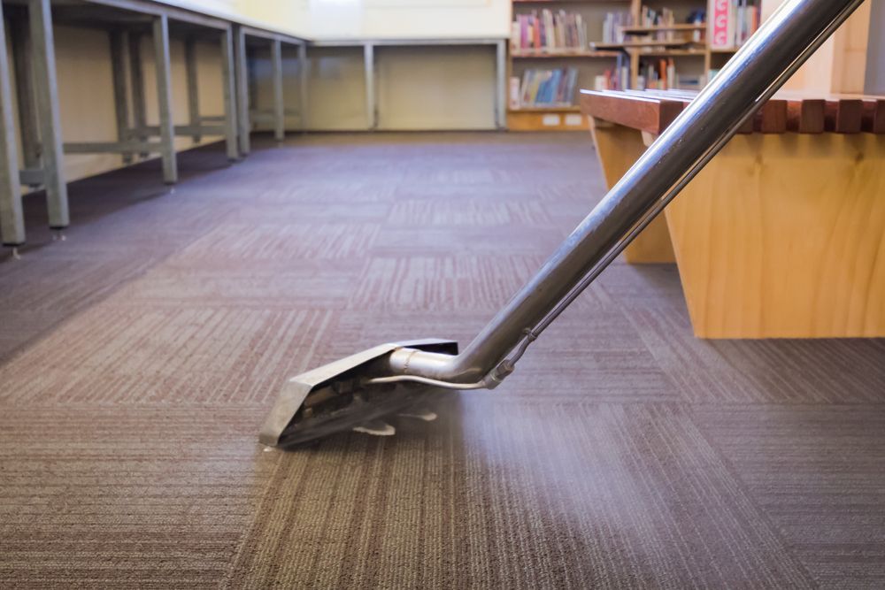 A Vacuum Cleaner Is Cleaning A Carpeted Floor In A Library — Citrus Clean Central Coast In The Entrance, NSW