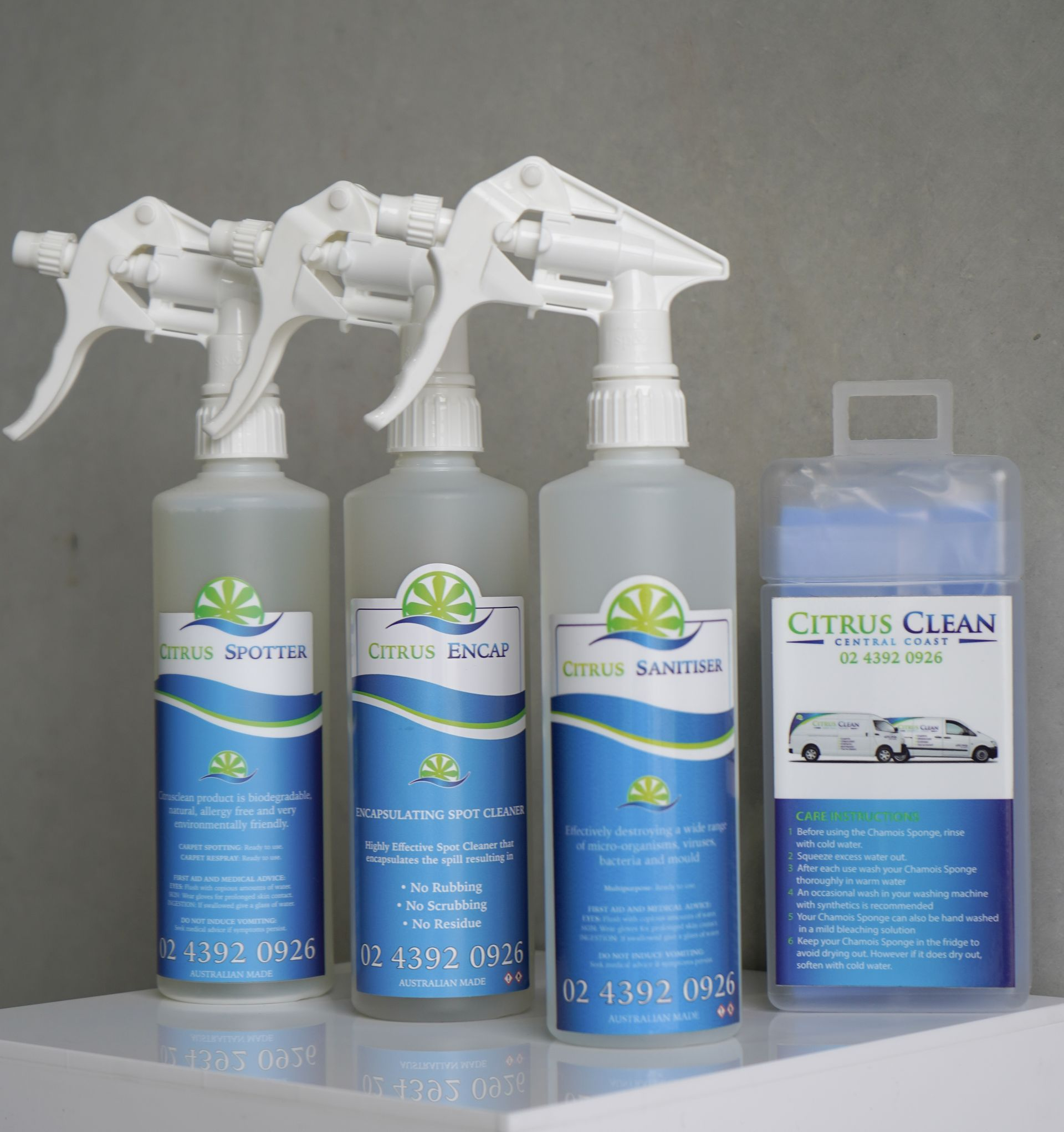 Four Citrus Clean Cleaning Products, Including Spray Bottles and a Wipe Package, on a White Surface — Citrus Clean Central Coast In Lake Haven, NSW