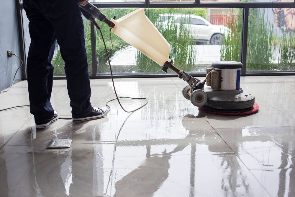 A Man And A Woman Are Cleaning An Office With A Vacuum Cleaner — Citrus Clean Central Coast In Lake Haven, NSW