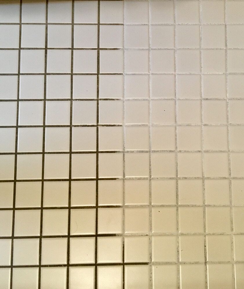 A Person Is Cleaning A Tile Wall With A Spatula — Citrus Clean Central Coast In Lake Haven, NSW