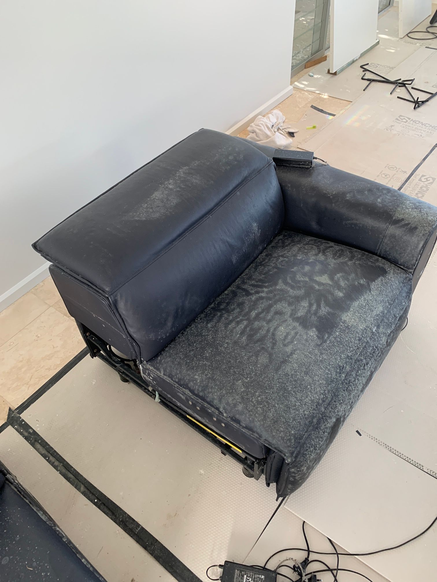 A Person Wearing Pink Gloves Is Cleaning A Black Leather Couch With A Sponge — Citrus Clean Central Coast In Lake Haven, NSW
