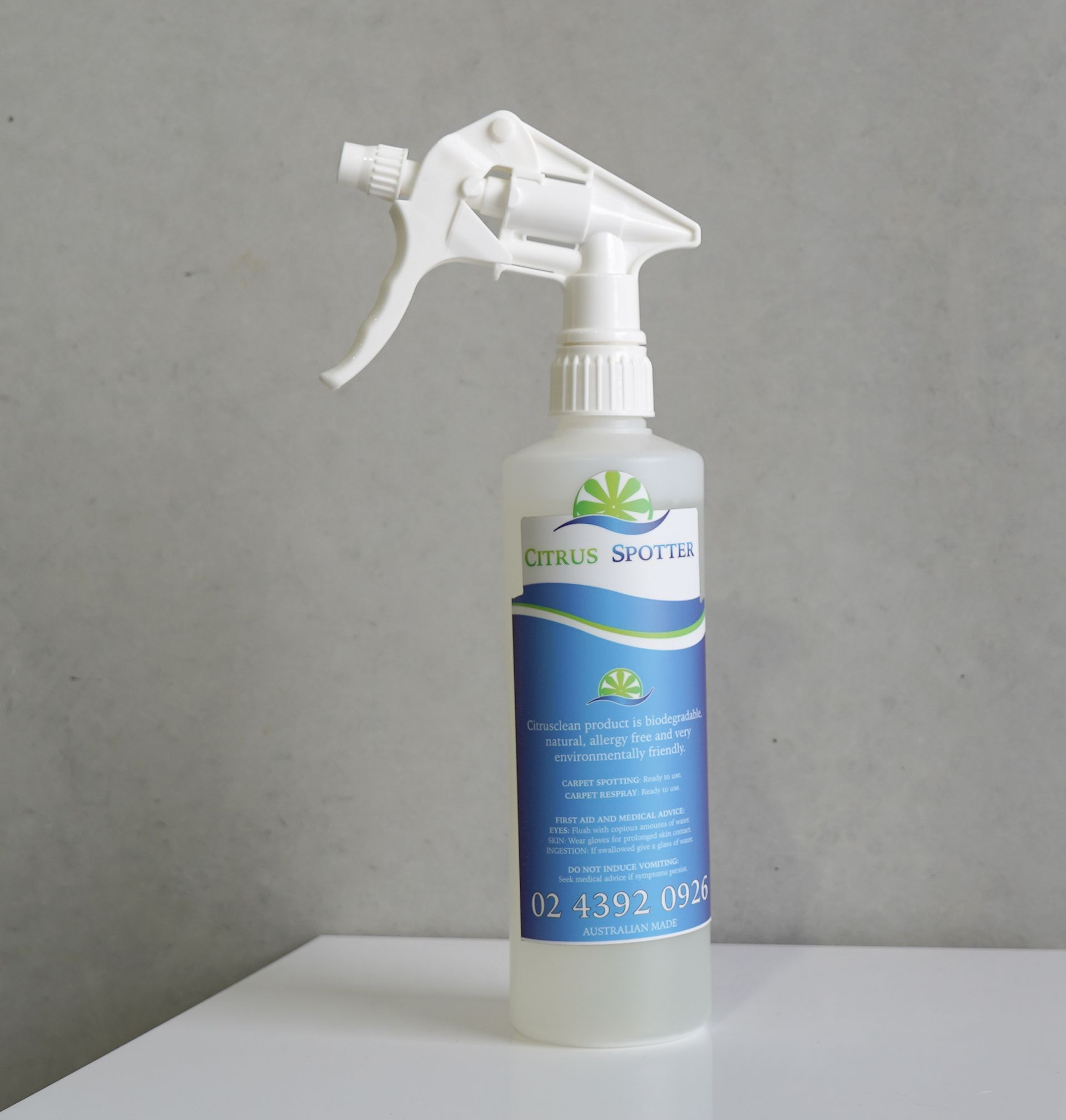 White Spray Bottle With Blue Label on a White Table Against a Gray Wall — Citrus Clean Central Coast In Lake Haven, NSW