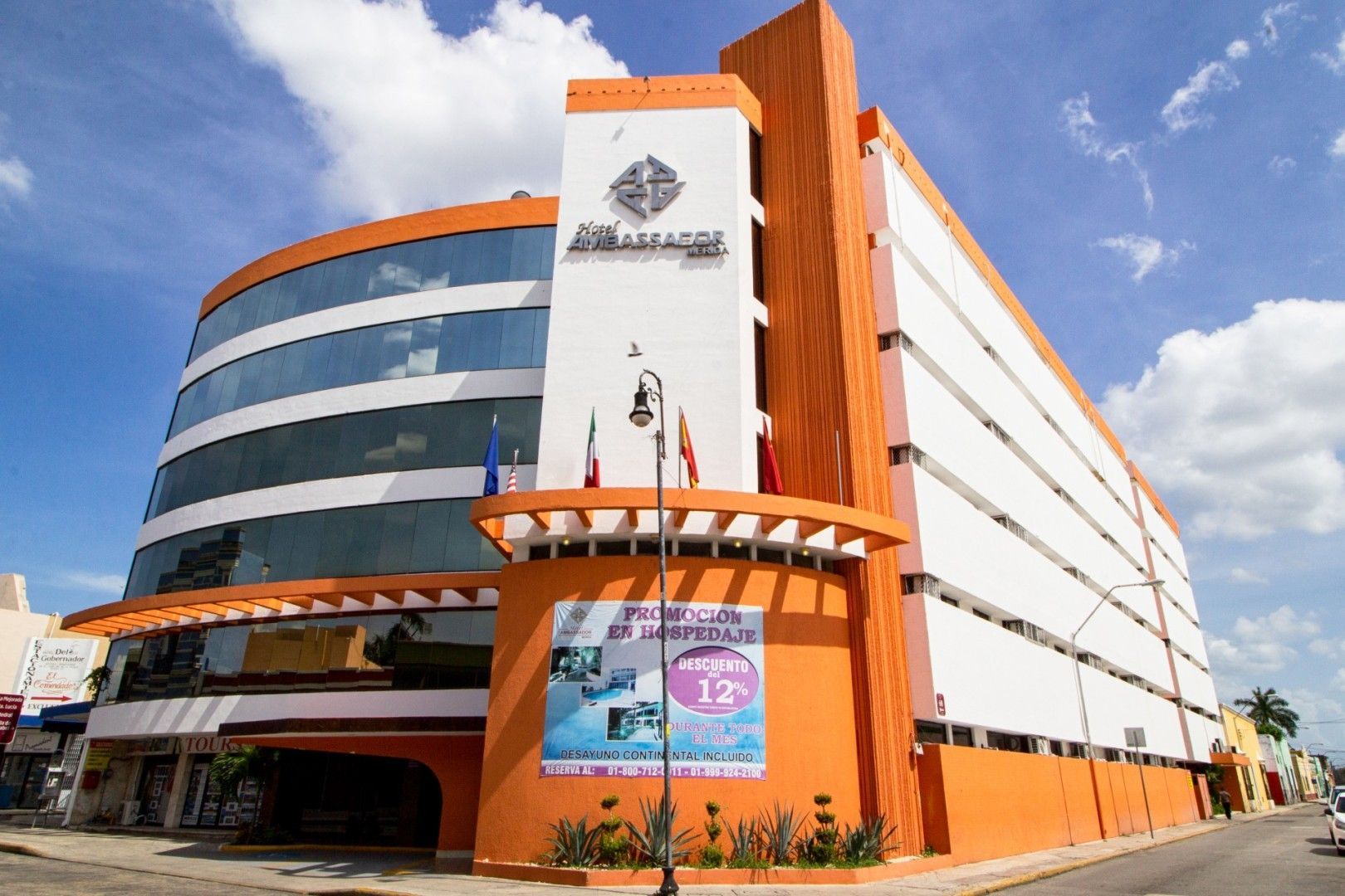 Edificio naranja y blanco con ventanas de vidrio; el cartel dice "Las Américas".