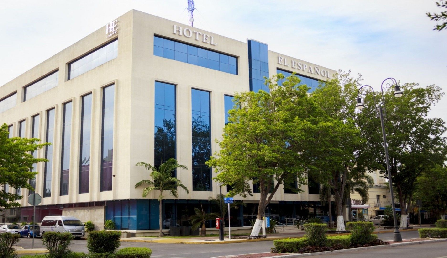 Edificio de hotel con altas ventanas azules y un cartel que dice "Hotel".
