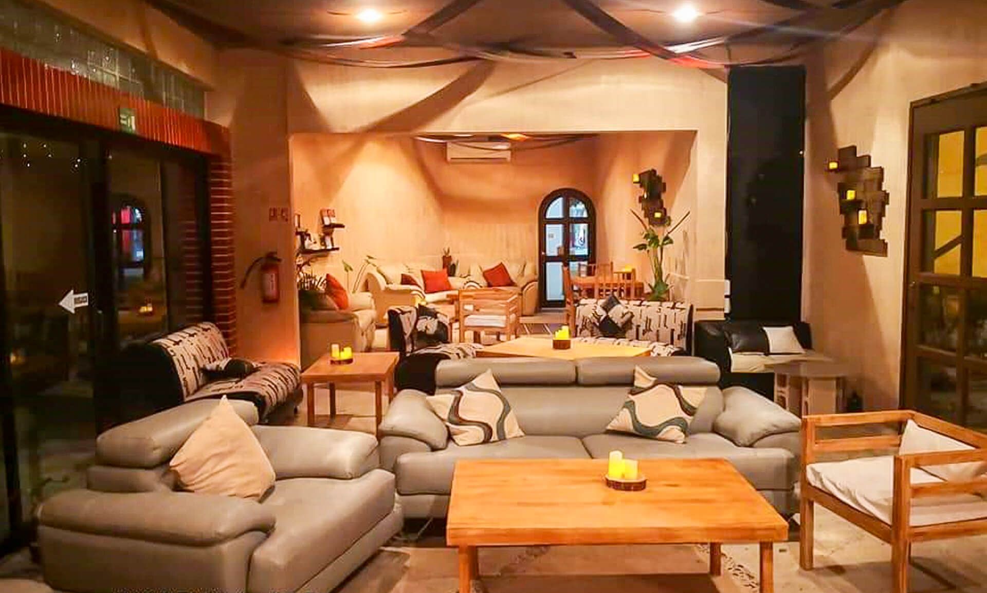 Acogedor interior de cafetería con sofás, mesas e iluminación ambiental, que crea un ambiente relajado para reunirse.