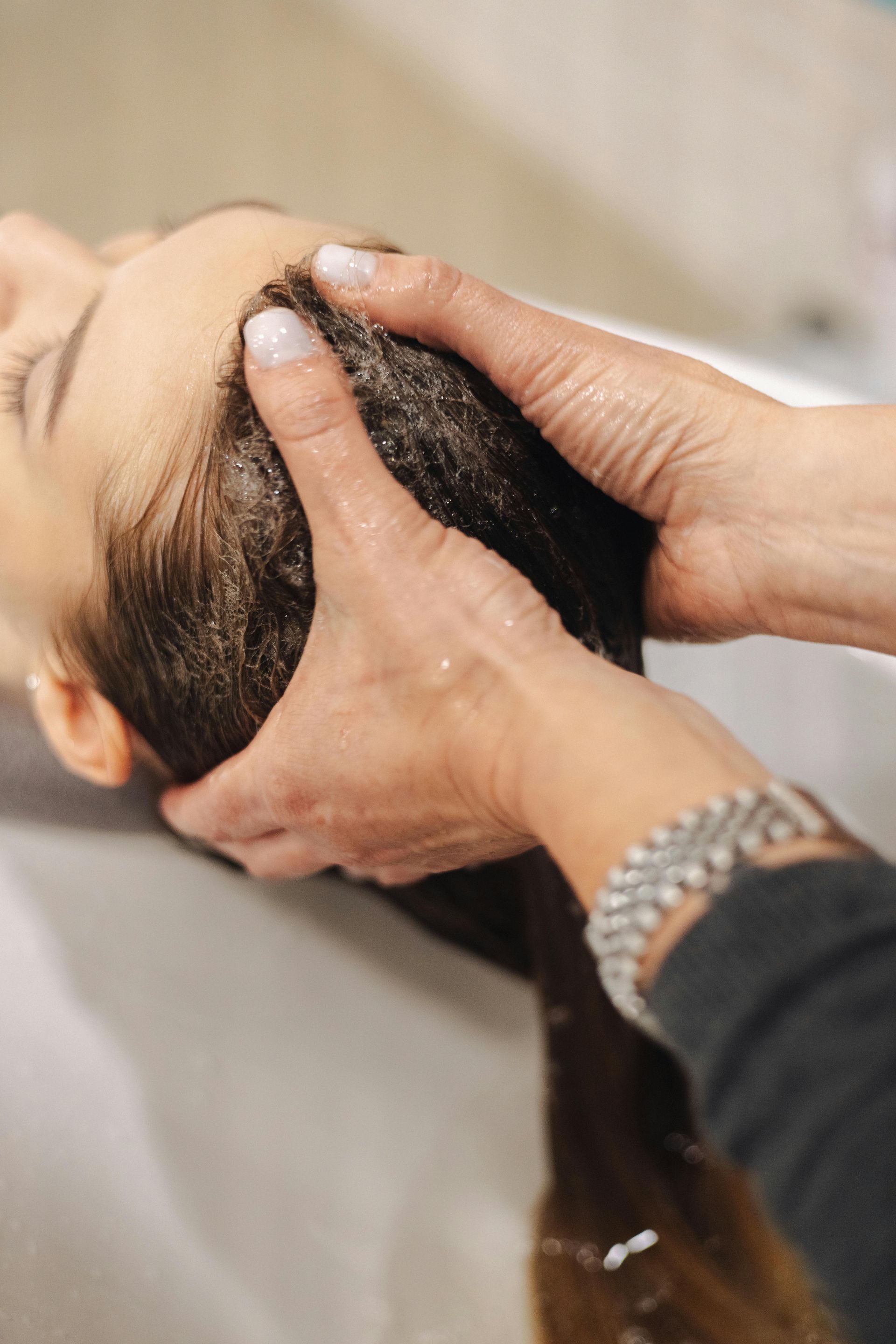 A woman is getting her hair washed at a salon.