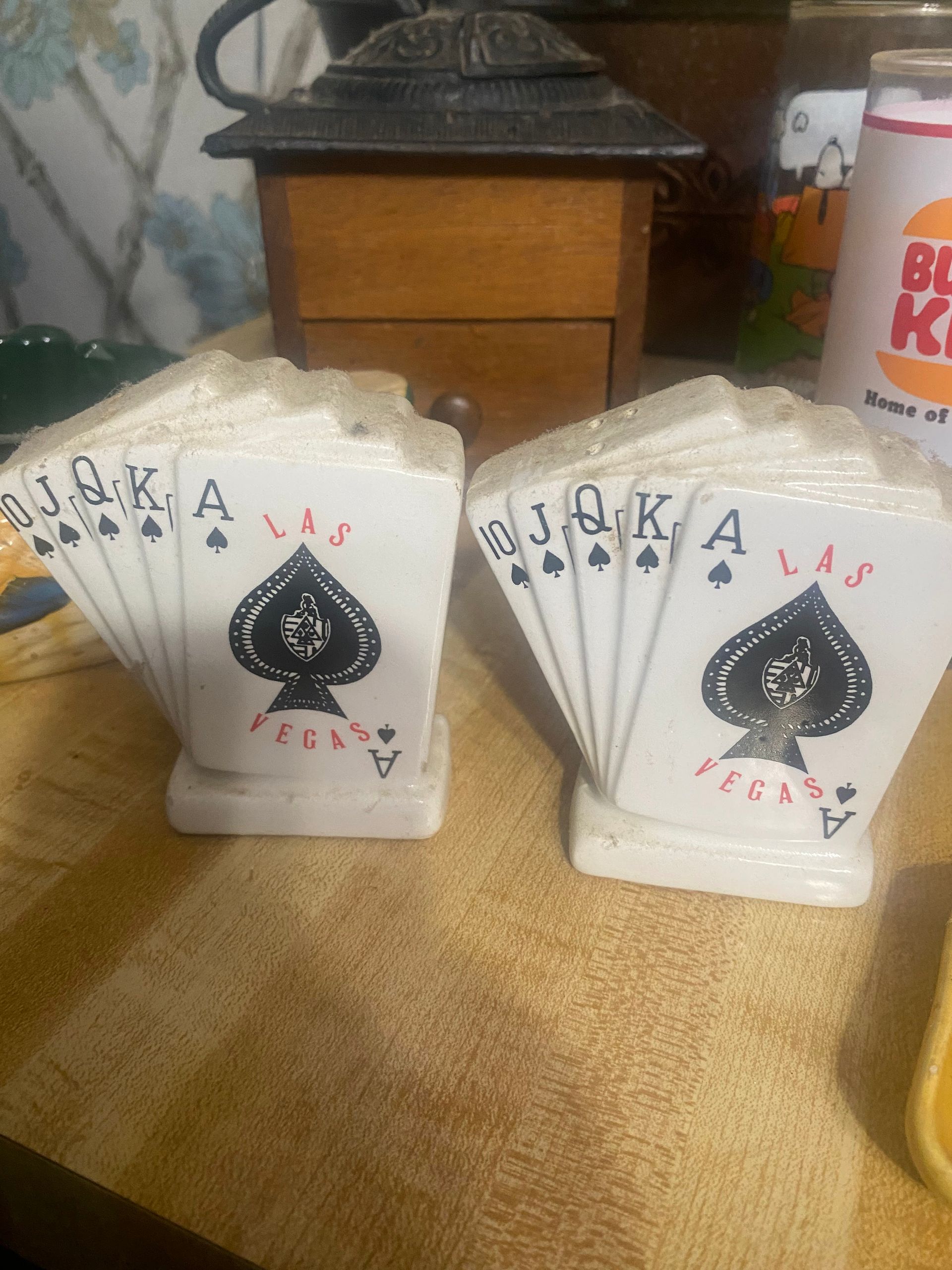 Two ceramic salt and pepper shakers shaped like playing card fans, with spade suit design.