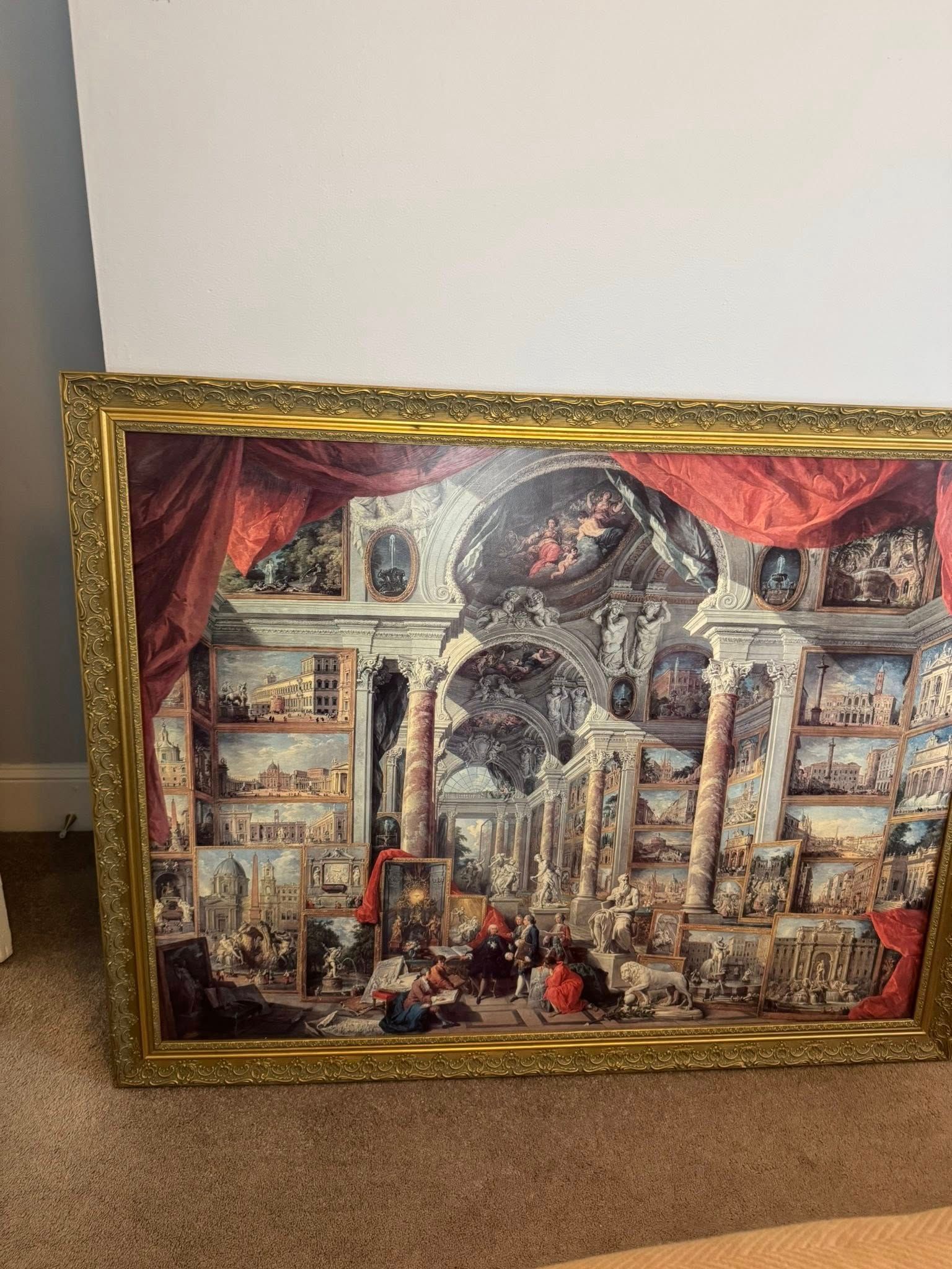 Elaborate architectural print with many figures, framed in gold.