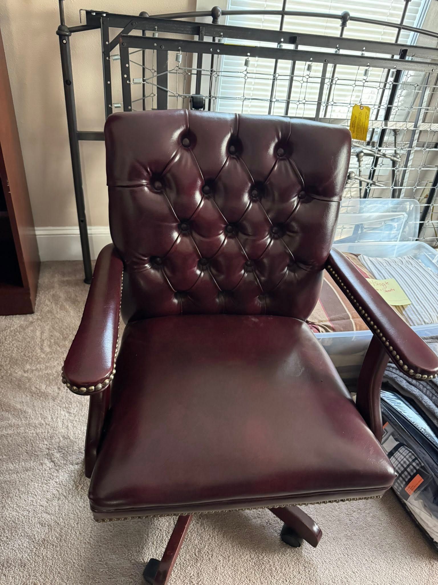 Burgundy leather office chair with tufted back and studded armrests.
