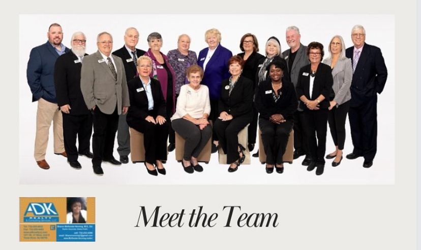 Green leather sofas in a living room with a window, lamps, and a rug.