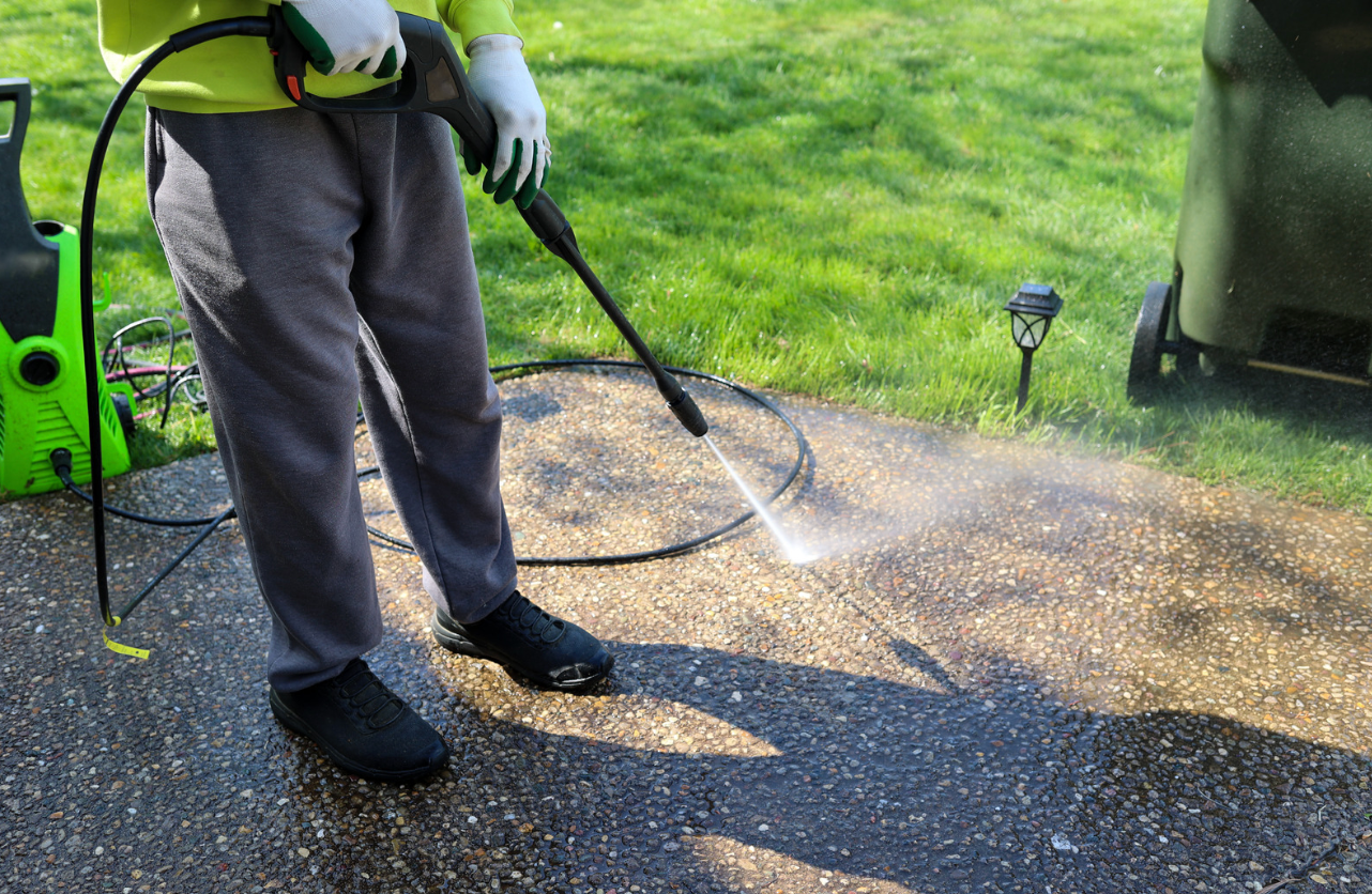 Asphalt driveway being pressure washed.