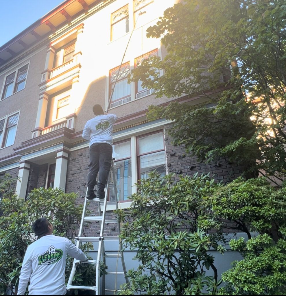 Professional window washer cleaning residential windows in Victoria, BC